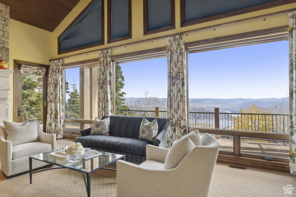 Sunroom / solarium featuring lofted ceiling, a mountain view, and wood ceiling