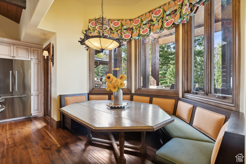 Dining area with breakfast area, lofted ceiling with beams, and dark wood-type flooring