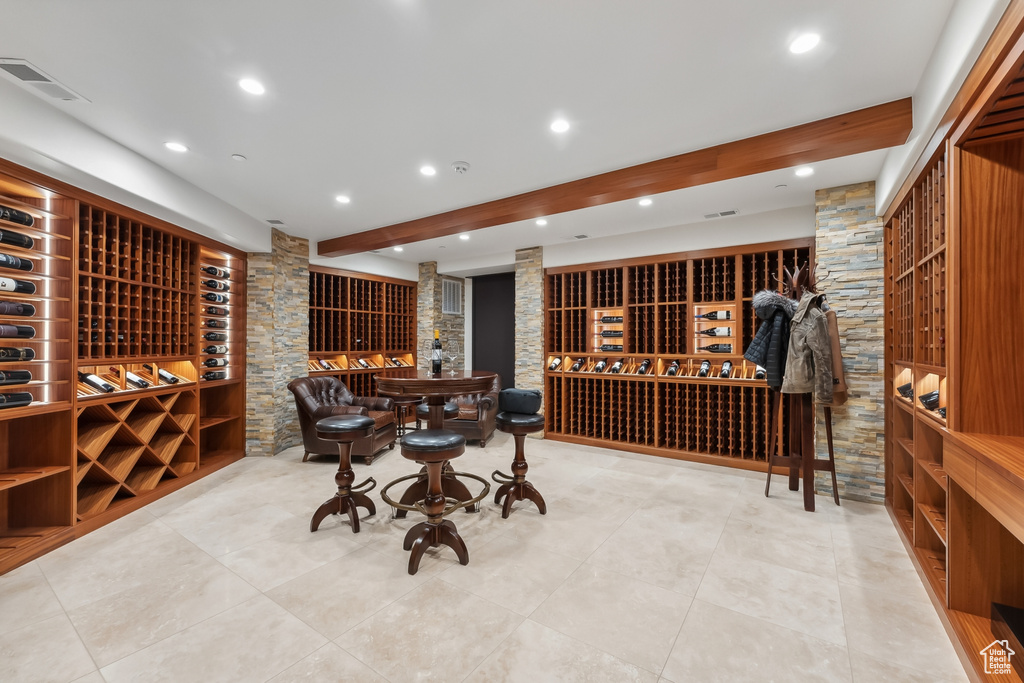 Wine cellar featuring beam ceiling