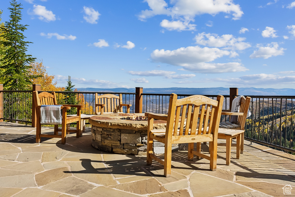 View of patio / terrace with a water and mountain view and a fire pit