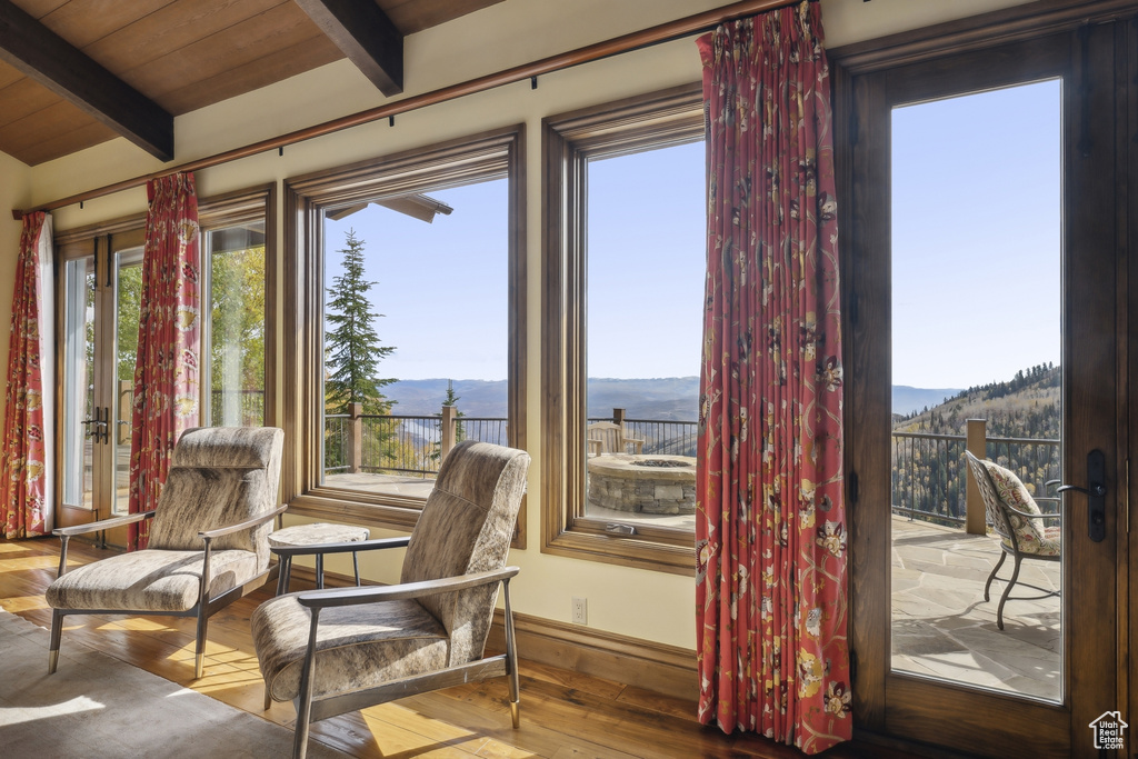 Sitting room featuring wooden ceiling, a mountain view, wood-type flooring, and vaulted ceiling with beams