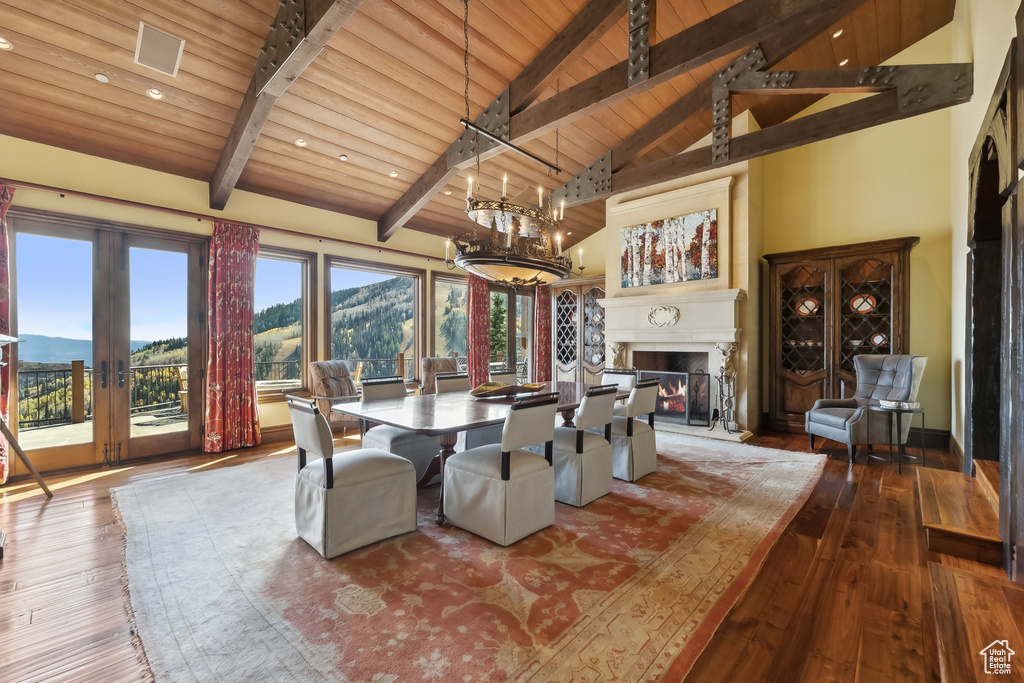 Dining room featuring a mountain view, high vaulted ceiling, wooden ceiling, and hardwood / wood-style floors