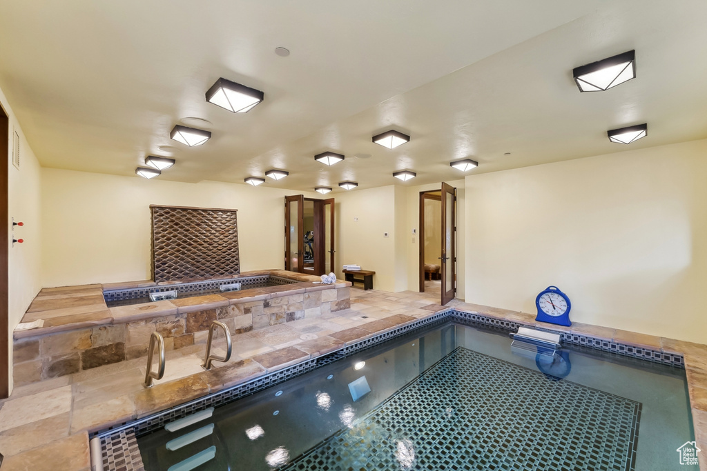 View of swimming pool with an indoor hot tub