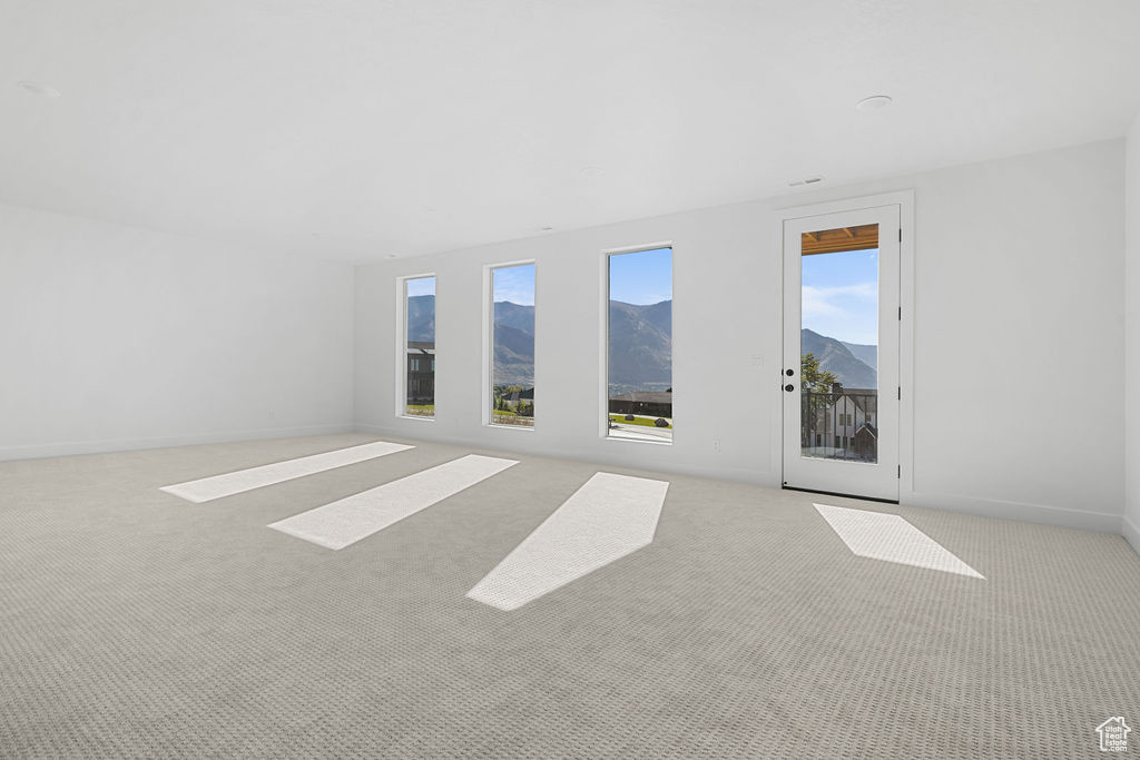 Unfurnished room featuring light carpet and a mountain view