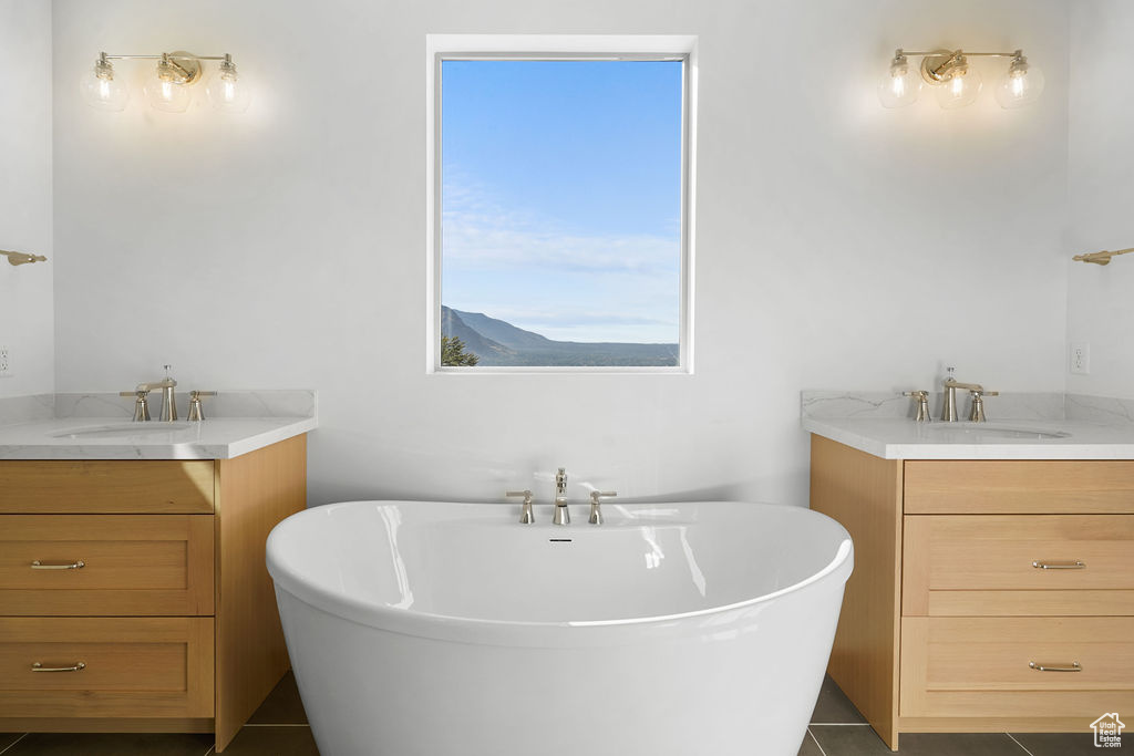 Bathroom featuring vanity, a tub to relax in, and tile patterned flooring