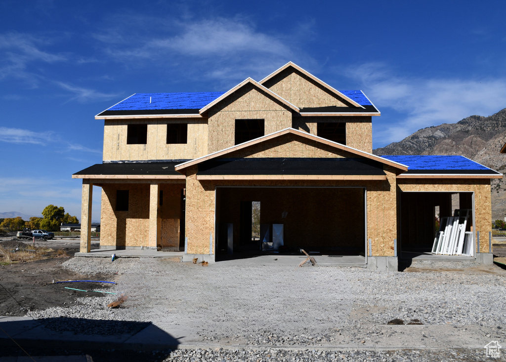 Property under construction featuring a mountain view and a patio area