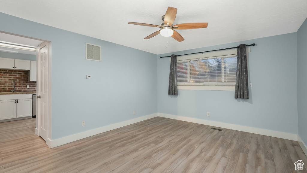 Spare room featuring sink, light wood-type flooring, and ceiling fan