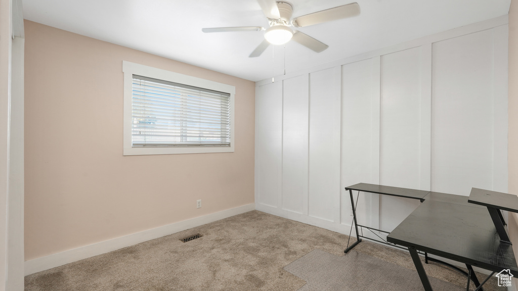 Carpeted office space with ceiling fan