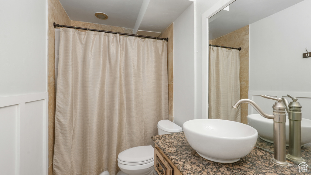 Bathroom featuring vanity, toilet, and a shower with curtain