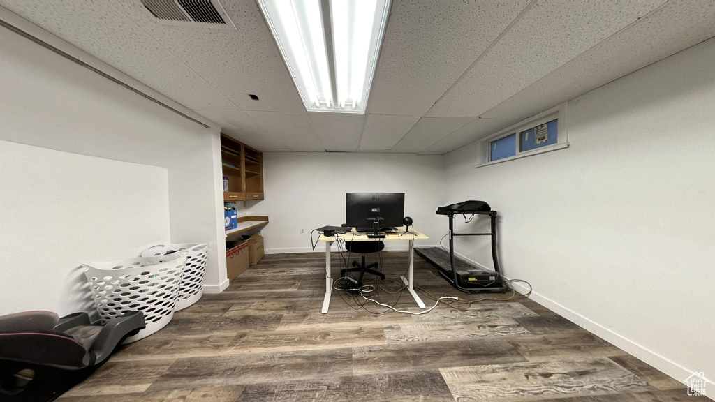 Office area featuring a paneled ceiling and wood-type flooring