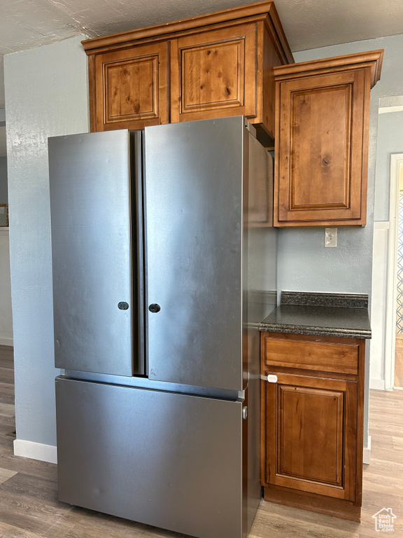 Kitchen featuring hardwood / wood-style floors and stainless steel fridge