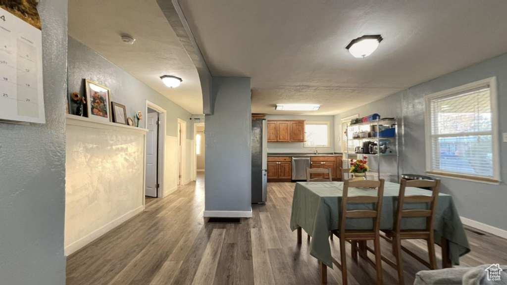 Dining space featuring a healthy amount of sunlight and dark wood-type flooring