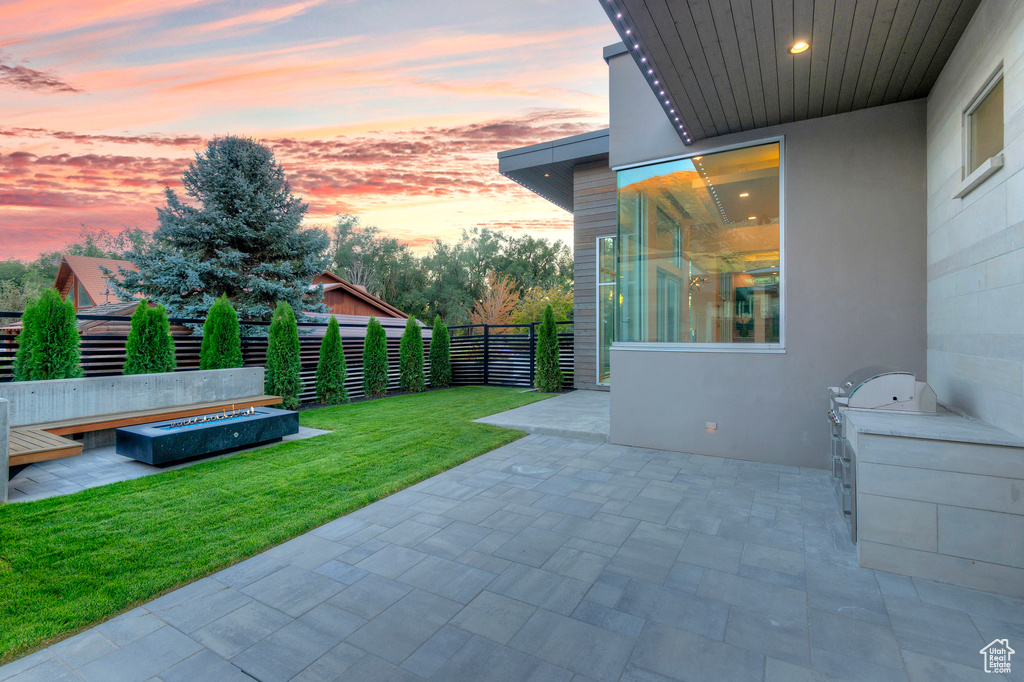 Patio terrace at dusk with a lawn