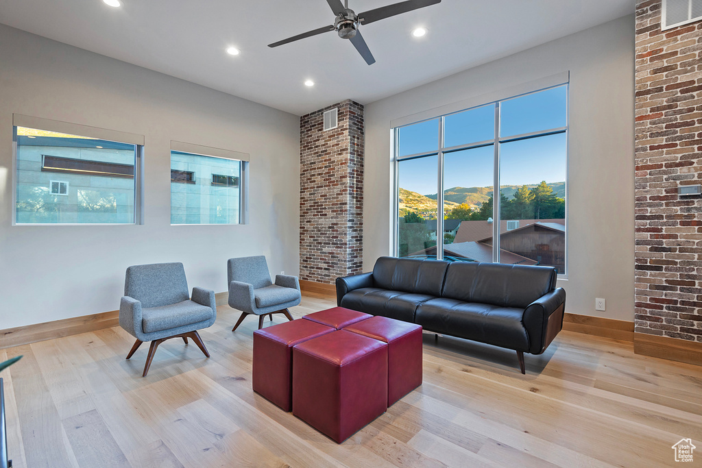 Living room with light hardwood / wood-style floors and ceiling fan