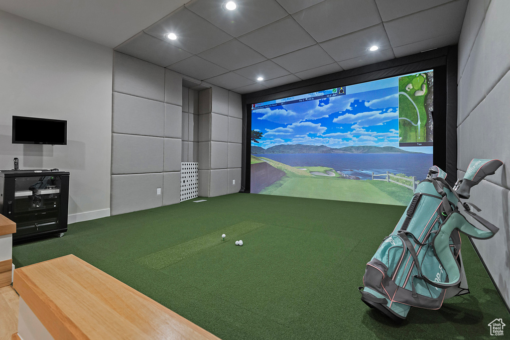 Rec room with a drop ceiling, carpet flooring, and golf simulator