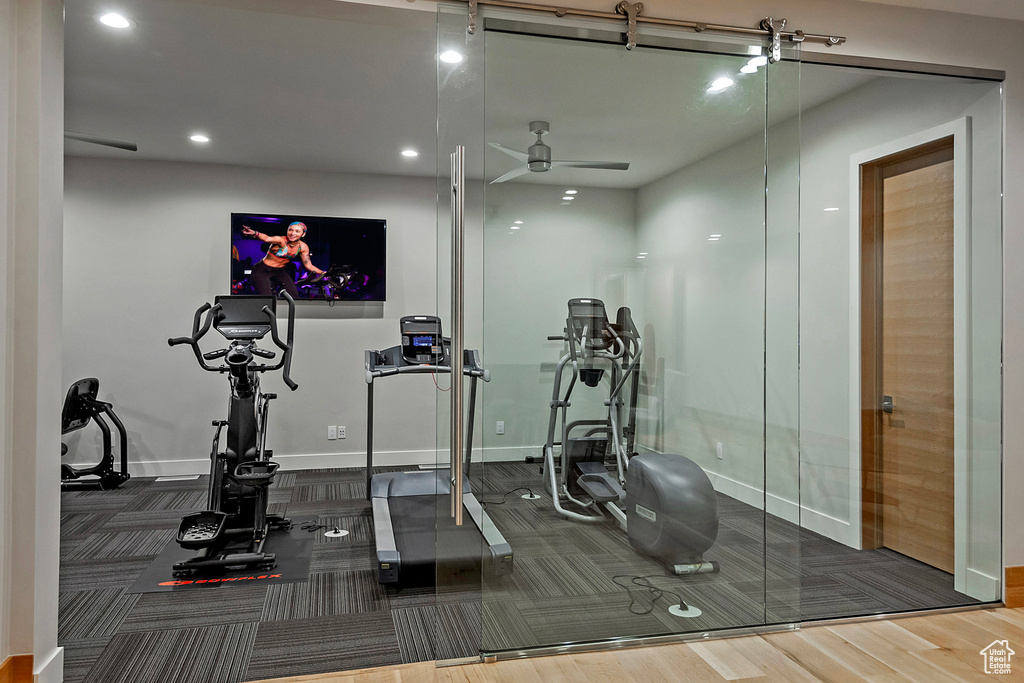 Exercise room featuring ceiling fan and hardwood / wood-style flooring