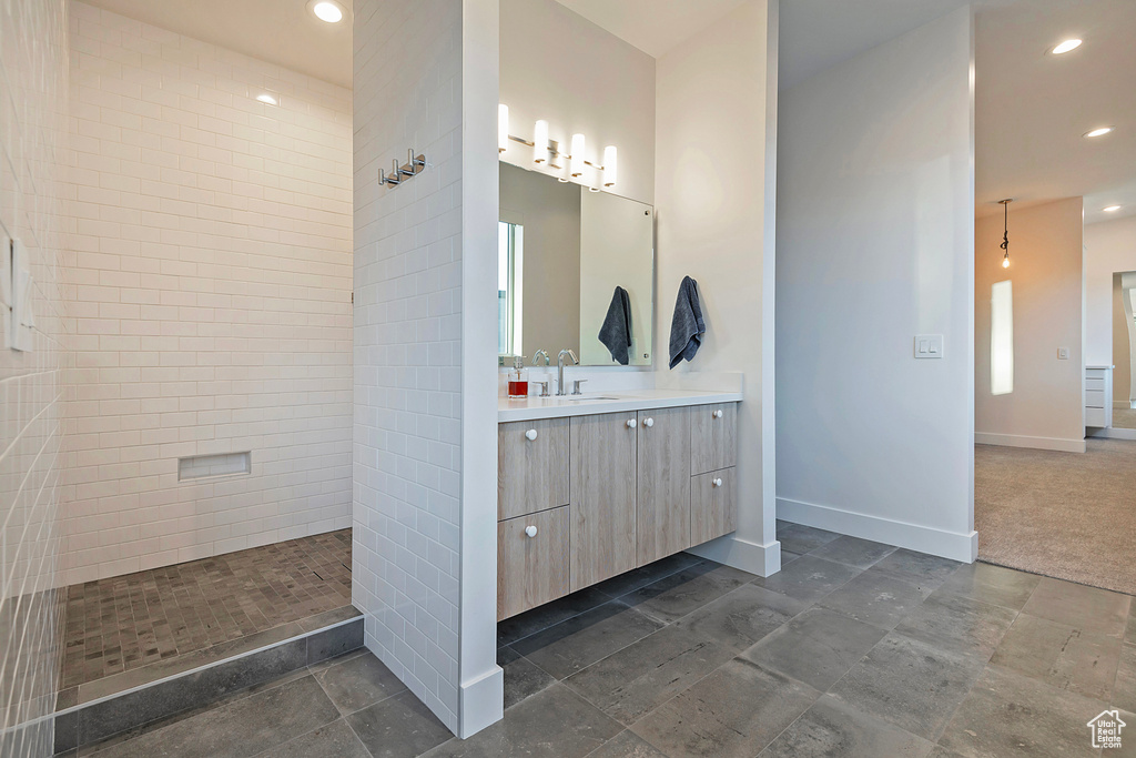 Bathroom with vanity and tiled shower