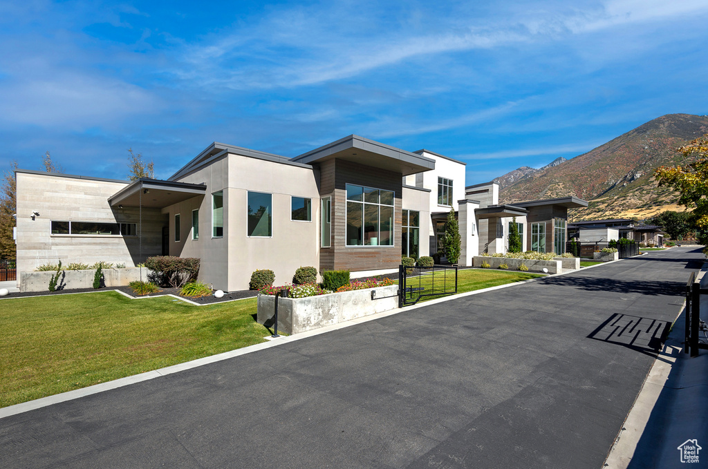 Contemporary home with a mountain view and a front lawn