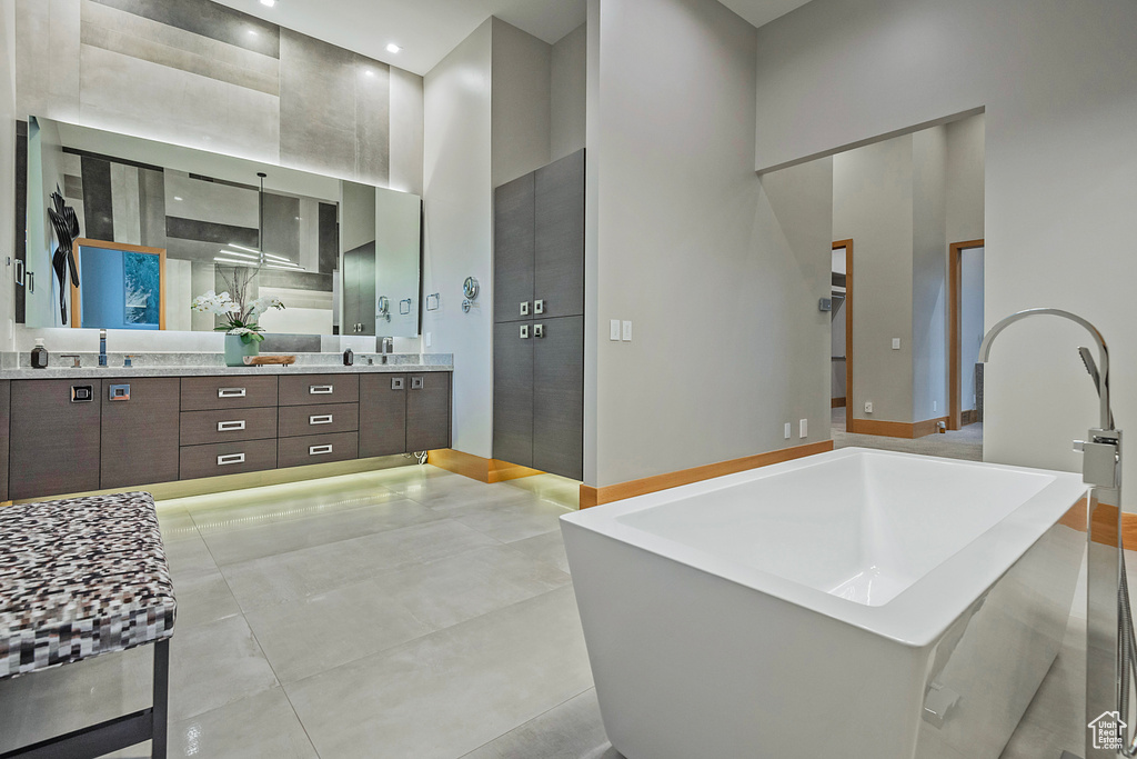 Bathroom featuring vanity, a bathtub, and a high ceiling