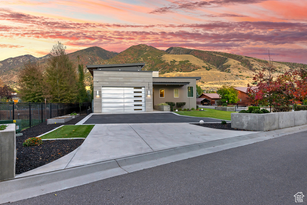 View of front facade featuring a yard, a garage, and a mountain view