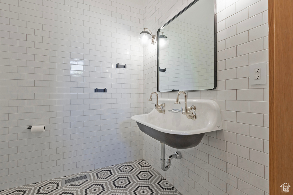 Bathroom featuring tile walls and sink