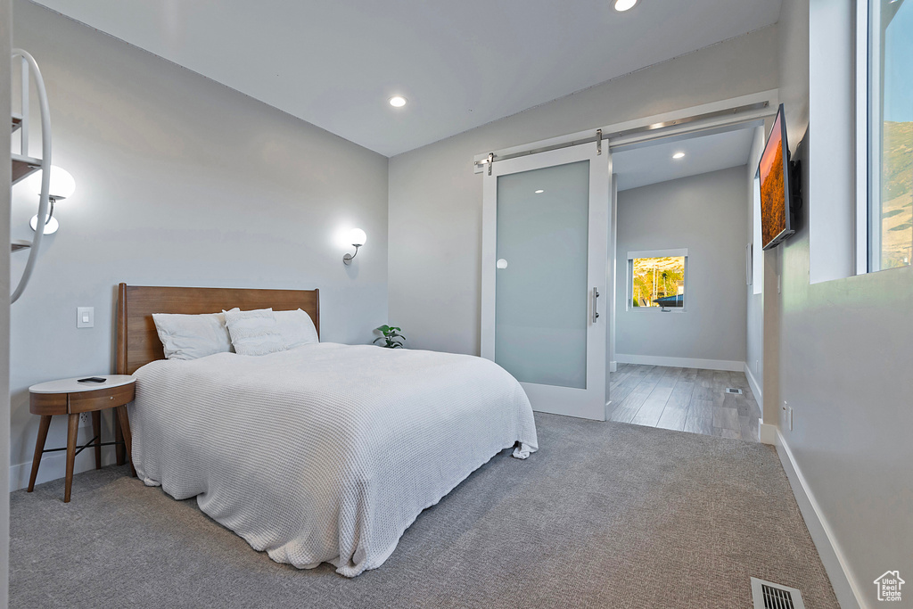 Bedroom featuring a barn door and hardwood / wood-style floors