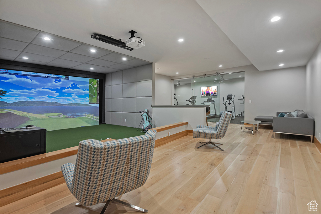 Game room featuring golf simulator, light wood-type flooring, and a drop ceiling