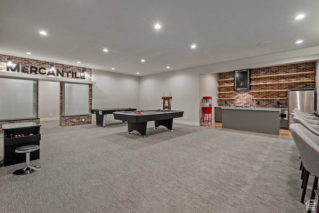 Playroom featuring pool table, brick wall, and light carpet