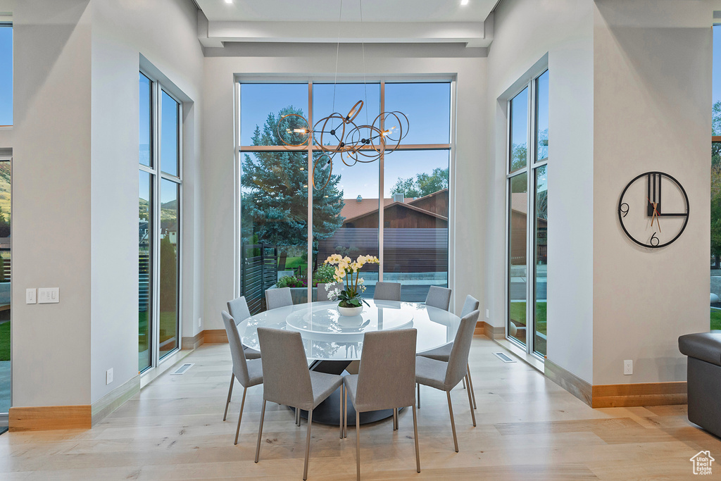 Dining room featuring a wealth of natural light, a notable chandelier, and light wood-type flooring