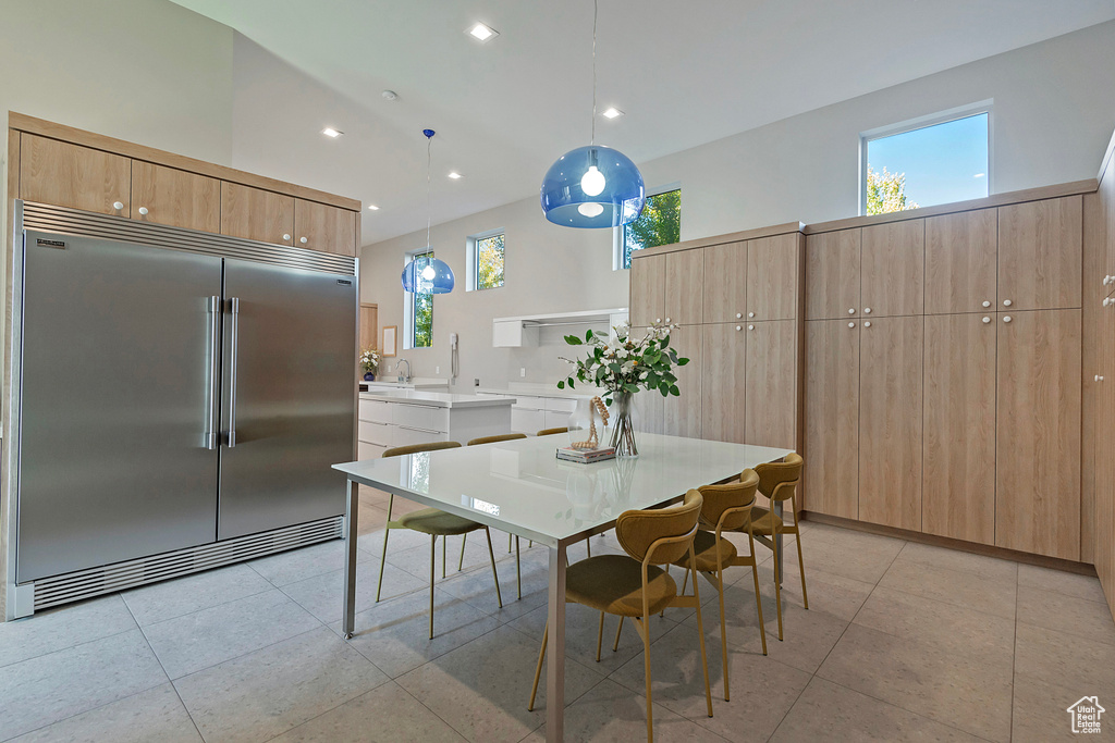 Dining space featuring light tile patterned flooring and a high ceiling