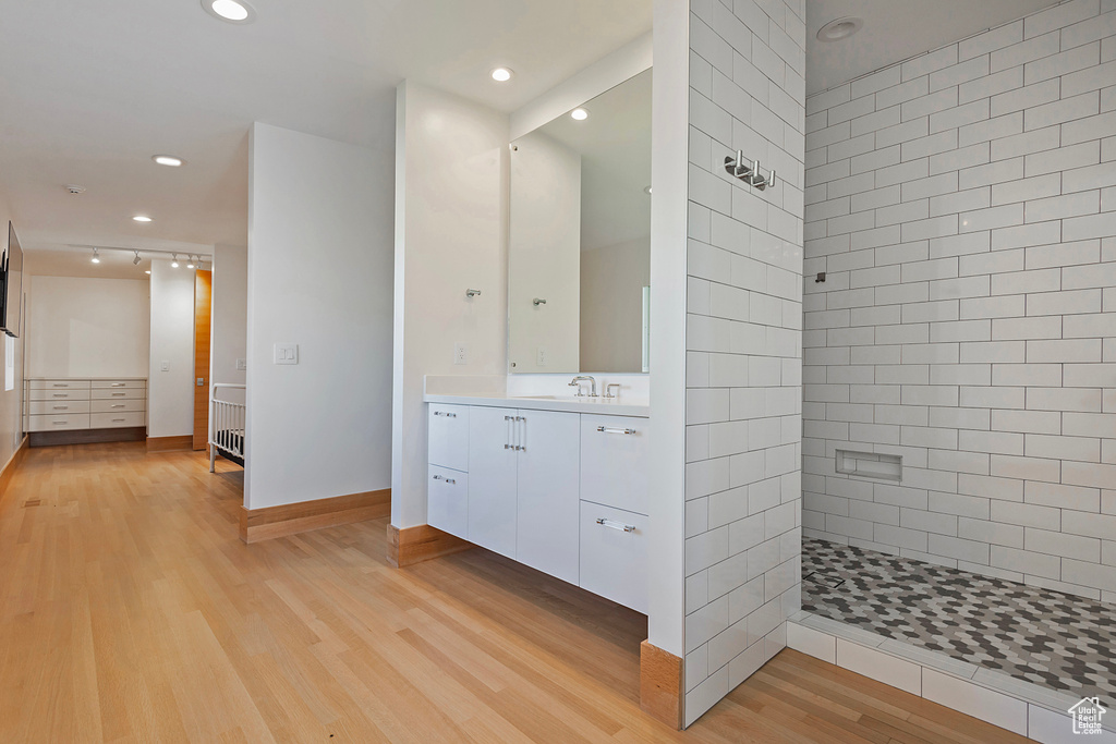 Bathroom with vanity, hardwood / wood-style floors, and tiled shower