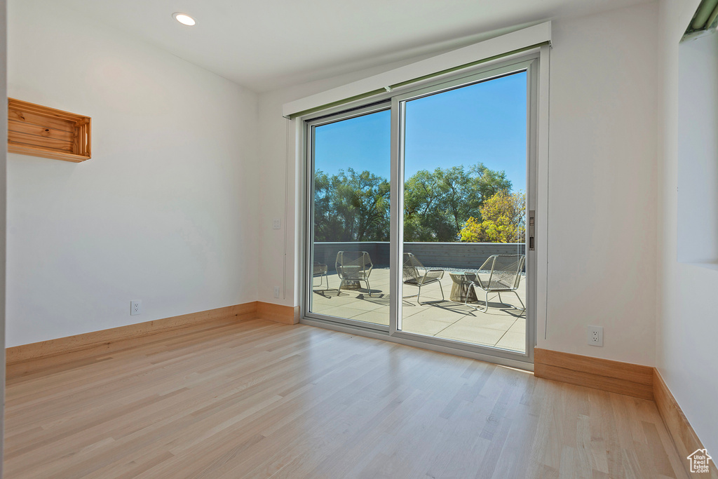 Empty room with light hardwood / wood-style floors