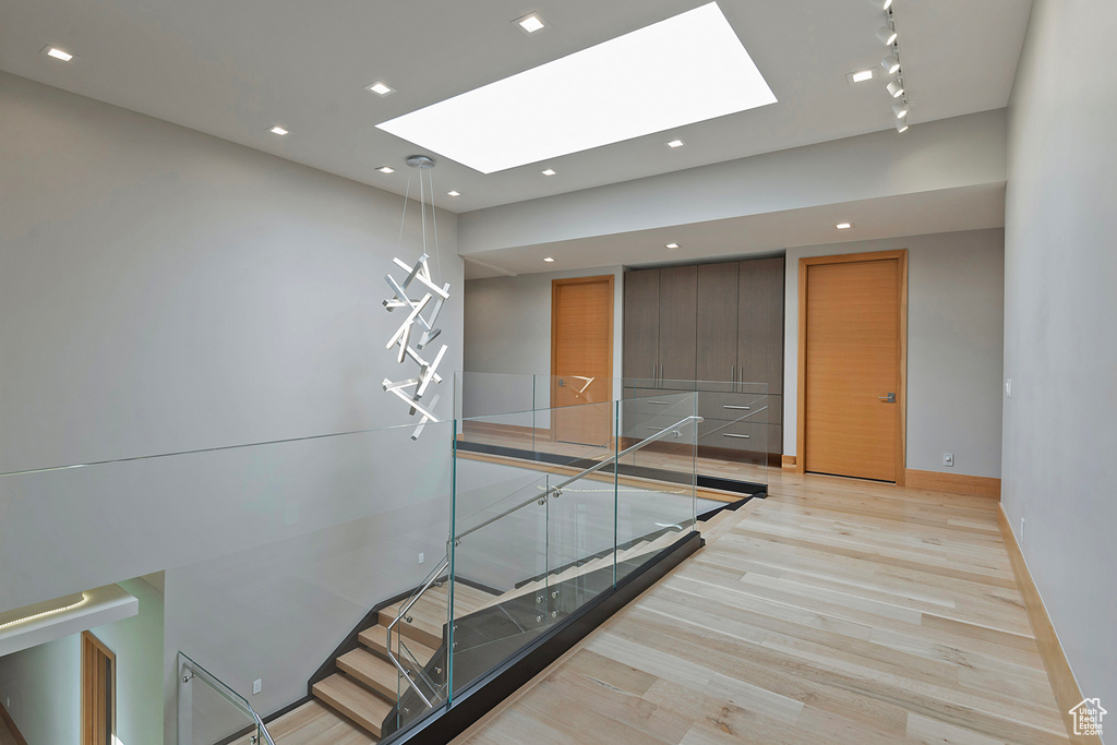 Corridor featuring light wood-type flooring and a skylight