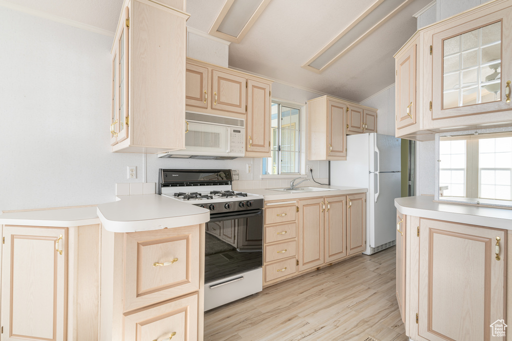 Kitchen featuring light brown cabinetry, light hardwood / wood-style flooring, crown molding, sink, and white appliances