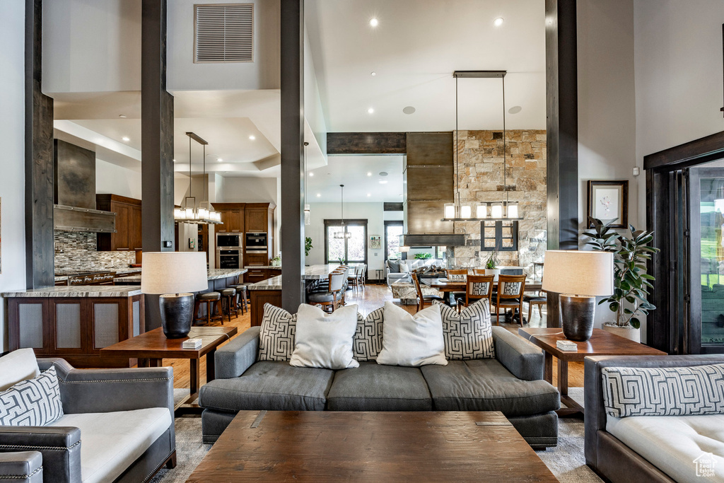 Living room with a high ceiling, a chandelier, and recessed lighting