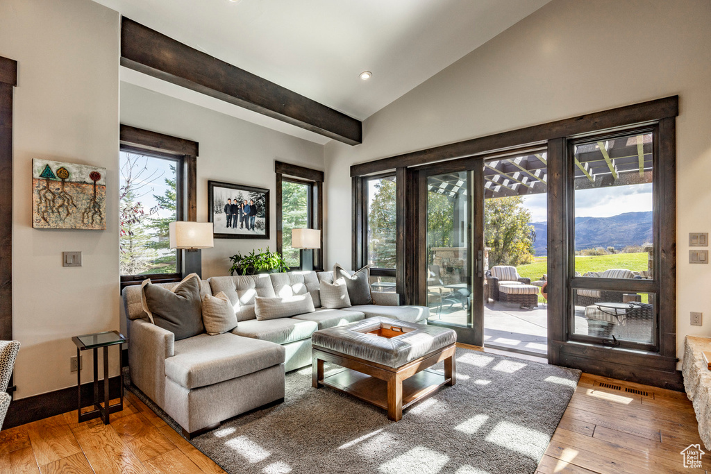 Living area featuring hardwood / wood-style floors, vaulted ceiling, a mountain view, and recessed lighting