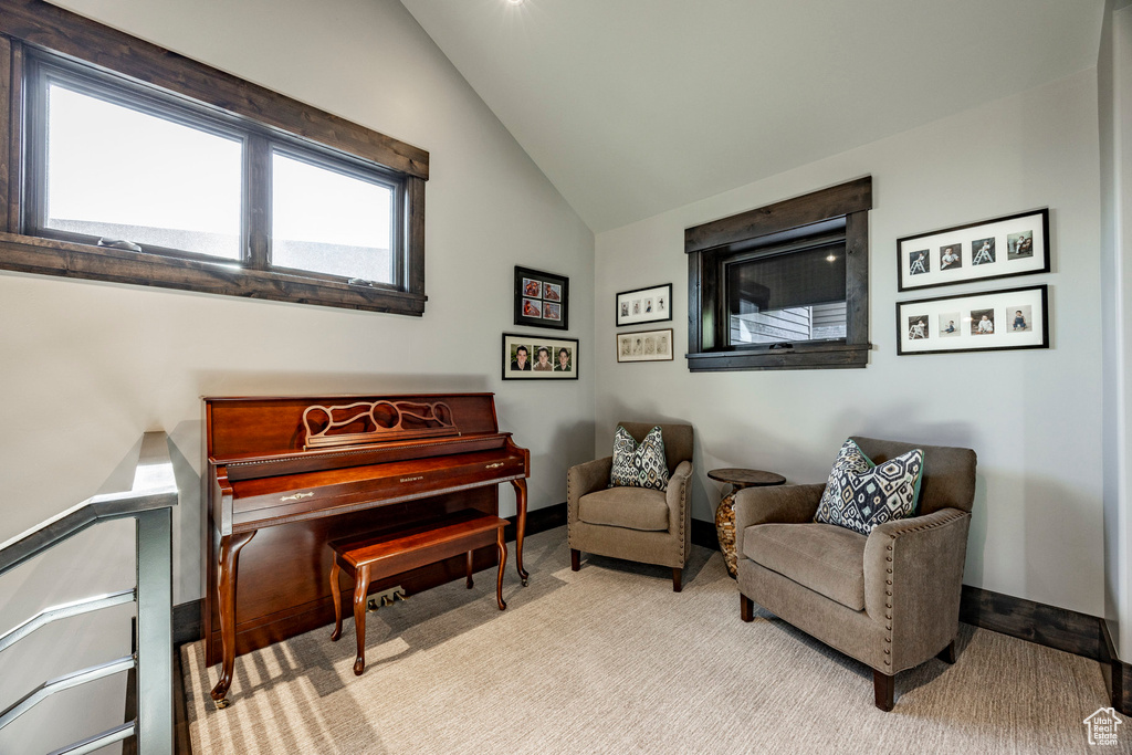 Living area with vaulted ceiling, carpet, and baseboards