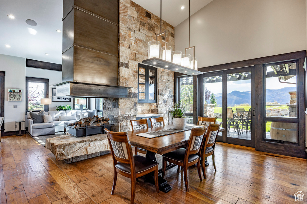 Dining space with high vaulted ceiling, hardwood / wood-style floors, a mountain view, and recessed lighting