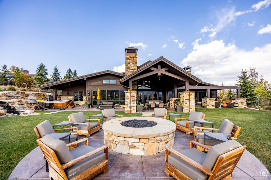View of patio featuring an outdoor living space with a fire pit