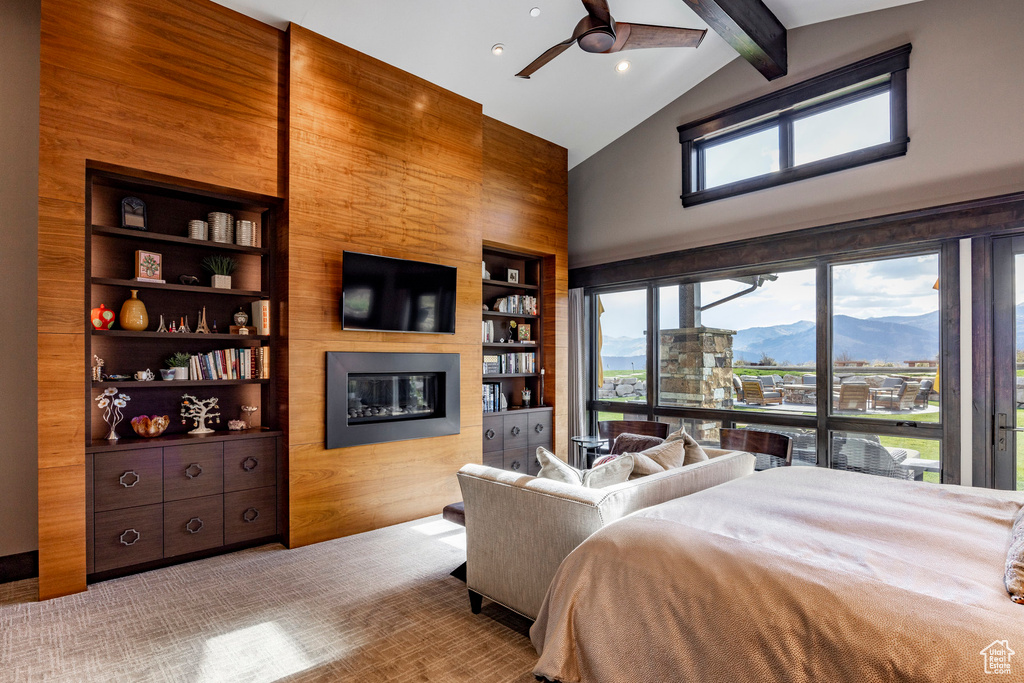 Bedroom with high vaulted ceiling, beam ceiling, and a large fireplace