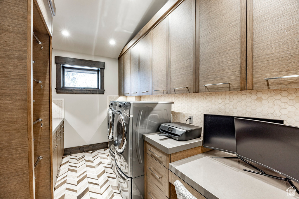 Laundry area featuring independent washer and dryer, cabinet space, and recessed lighting