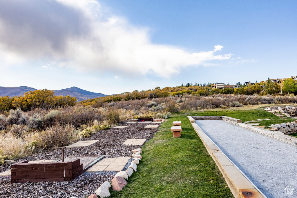 View of grassy yard featuring a bocce ball area and a mountain view