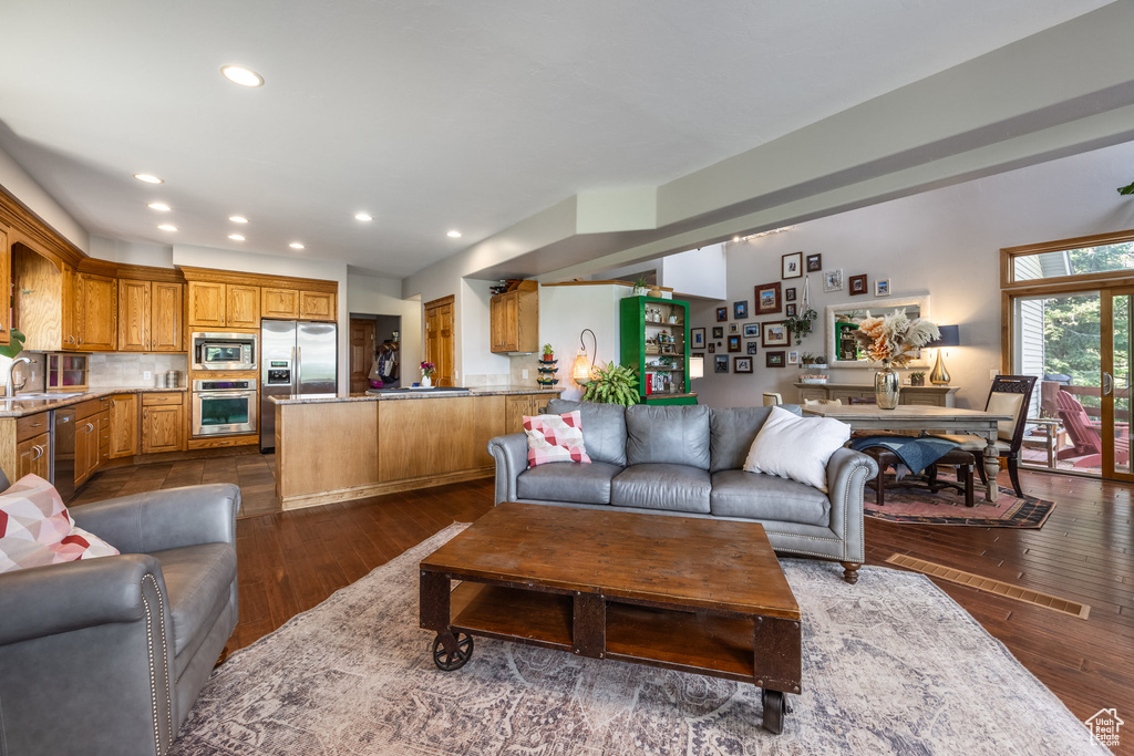 Living area with dark wood-type flooring and recessed lighting