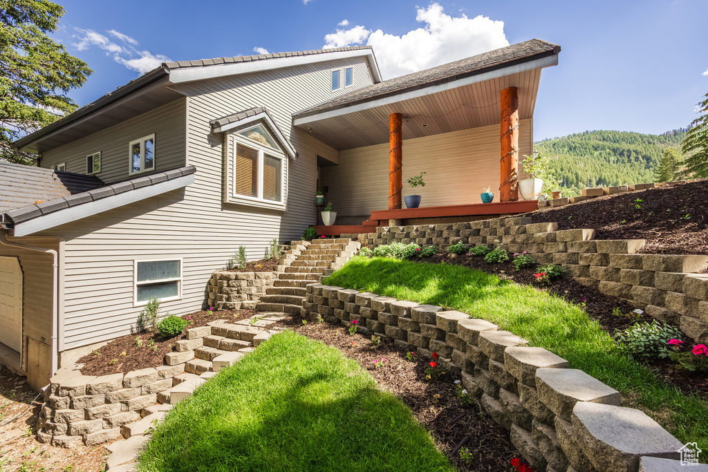 View of front of home featuring stairs, covered porch, and a mountain view