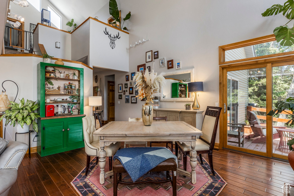 Dining area featuring a towering ceiling and hardwood / wood-style flooring