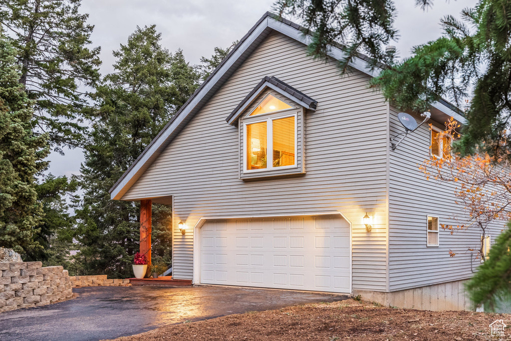View of property exterior featuring driveway and a garage