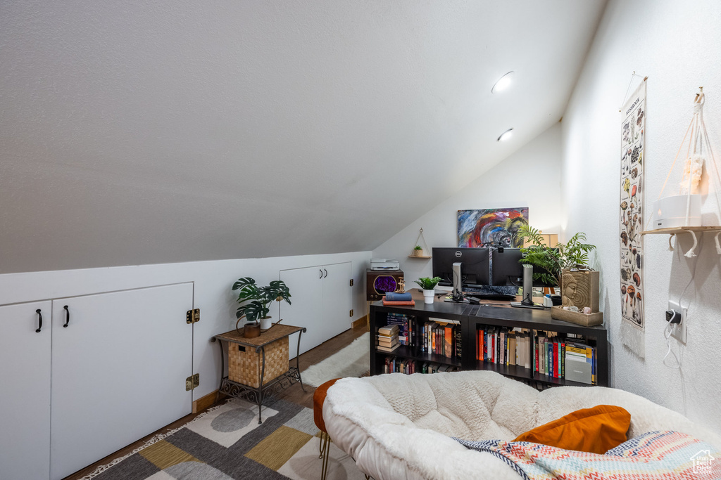 Home office with lofted ceiling and wood-type flooring