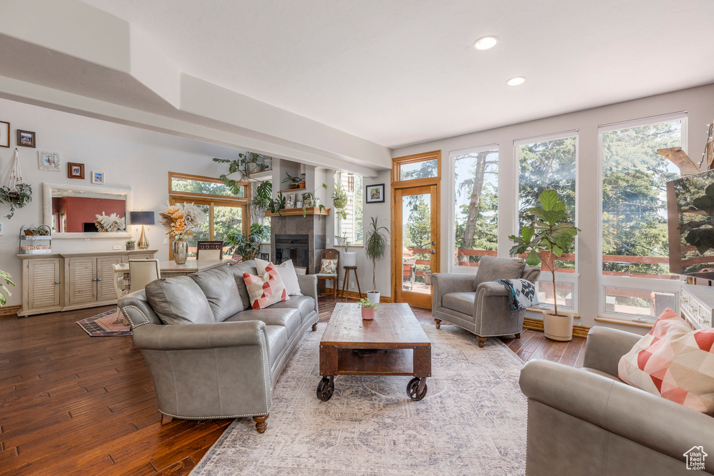 Living room with recessed lighting, hardwood / wood-style floors, and a glass covered fireplace