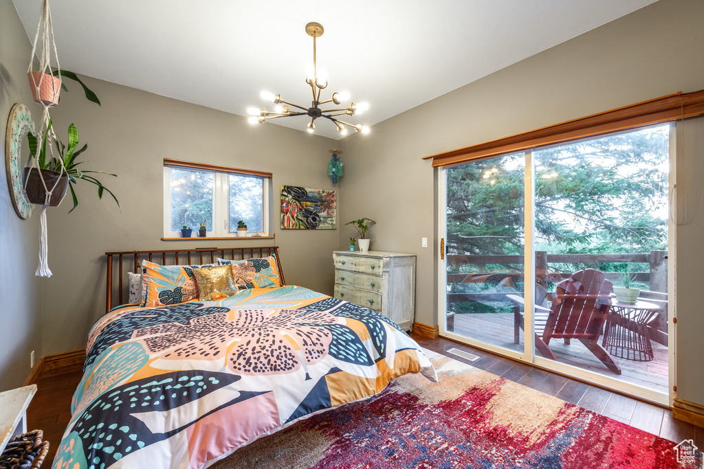 Bedroom with hardwood / wood-style flooring, access to outside, and multiple windows