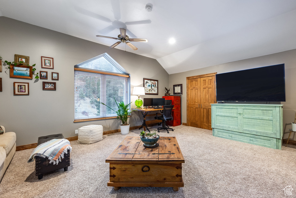 Carpeted living room with lofted ceiling and ceiling fan